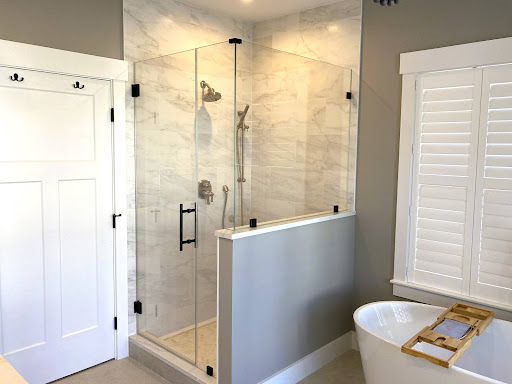 Frameless glass shower enclosure with a wall.