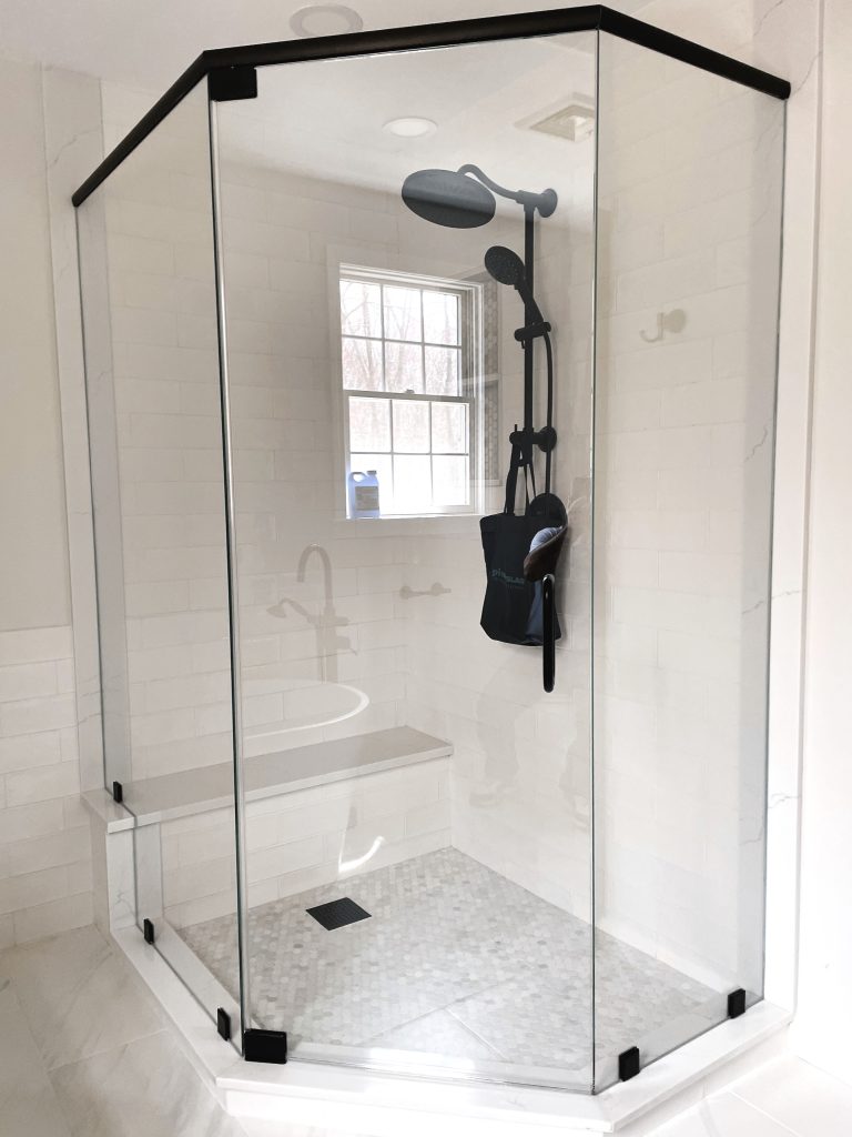 Frameless neo-angle shower with a bench